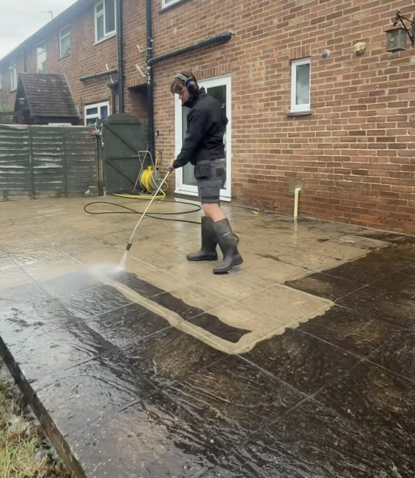 Moss being cleared from concrete tiles